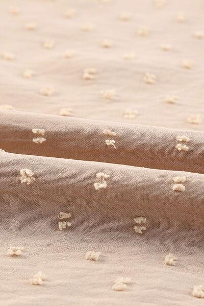 a close up of a bed sheet with small white flowers on it