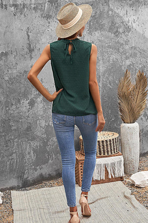 a woman wearing a green top and blue jeans