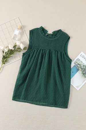 a baby girl's green dress next to a white flower