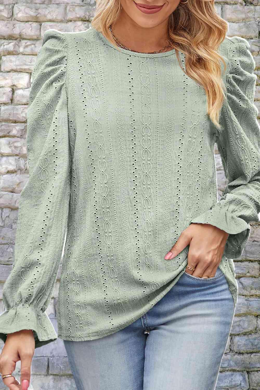 a woman wearing a green sweater and jeans