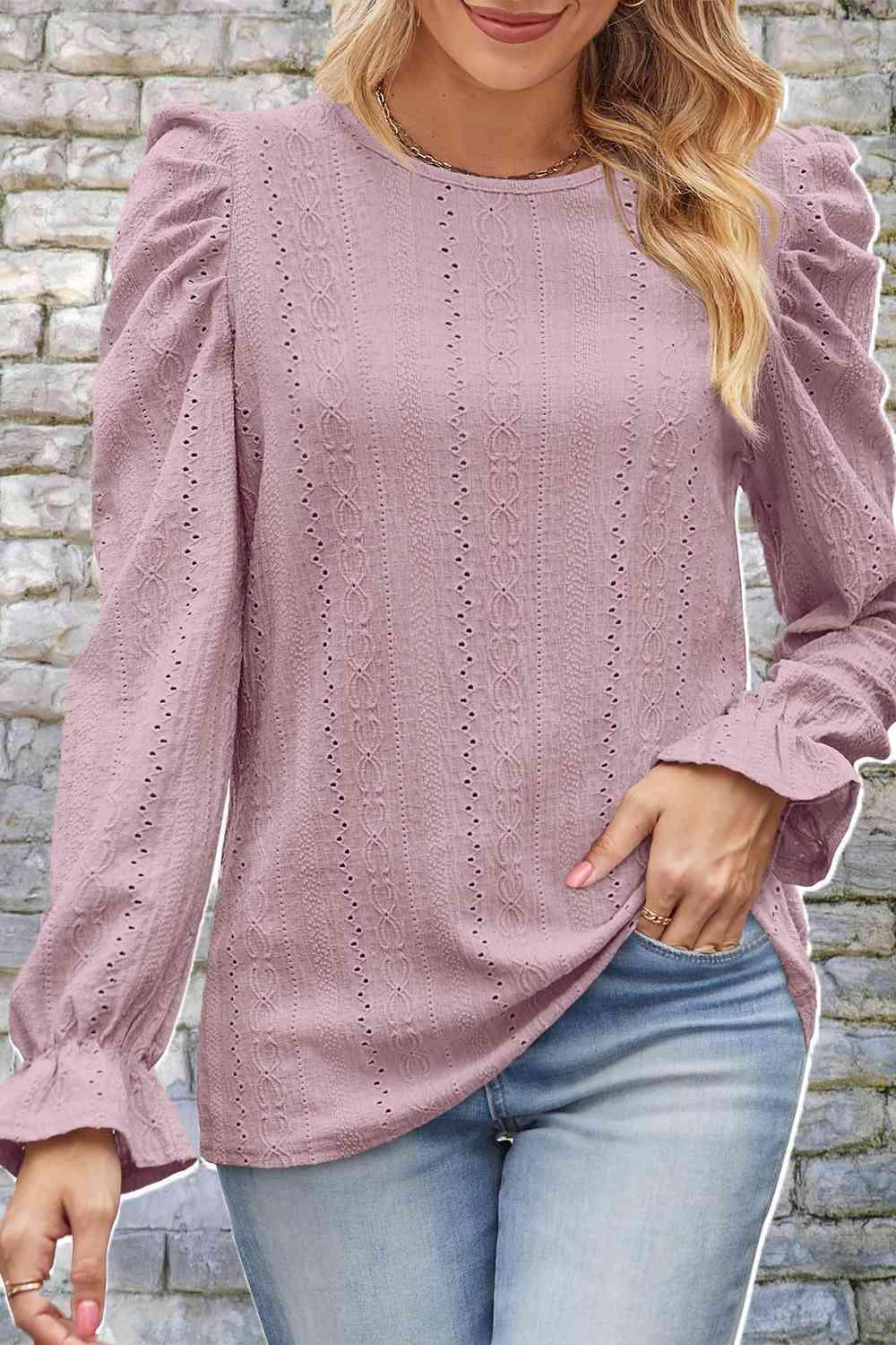 a woman wearing a pink sweater and jeans