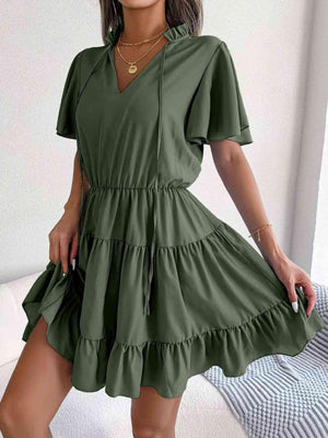 a woman in a green dress posing for the camera