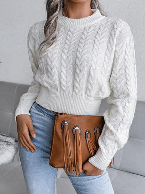 a woman wearing a white sweater and jeans