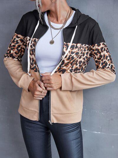 a woman wearing a leopard print jacket and black pants