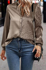 a woman wearing a leopard print blouse and jeans