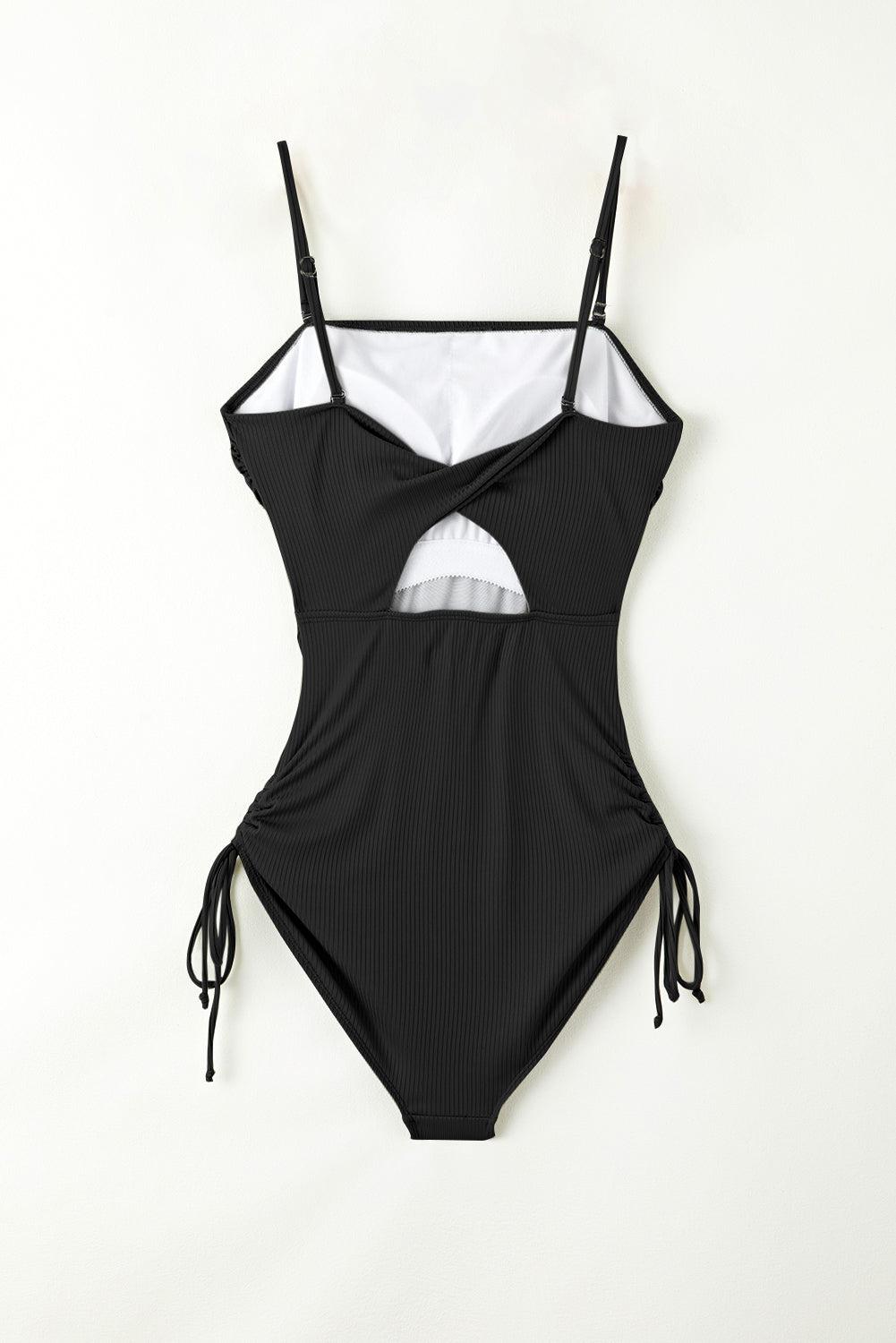 a black and white one piece swimsuit hanging on a wall