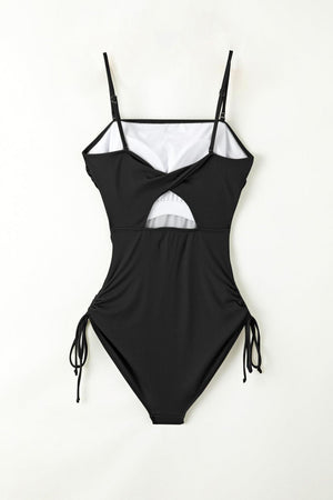 a black and white one piece swimsuit hanging on a wall