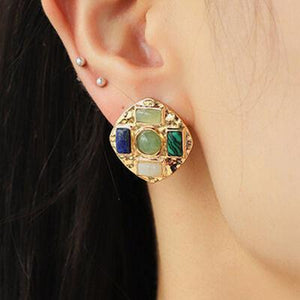 a close up of a person wearing a pair of earrings