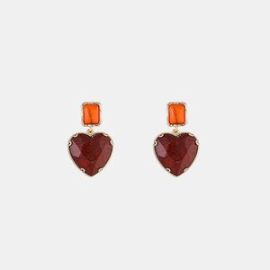 a pair of earrings with a heart shaped stone