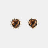 a pair of earrings with a heart shaped tortoise shell
