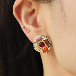 a close up of a person wearing a pair of earrings