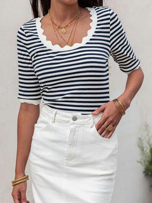 a woman wearing a striped top and white skirt