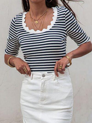 a woman in a striped shirt and white skirt