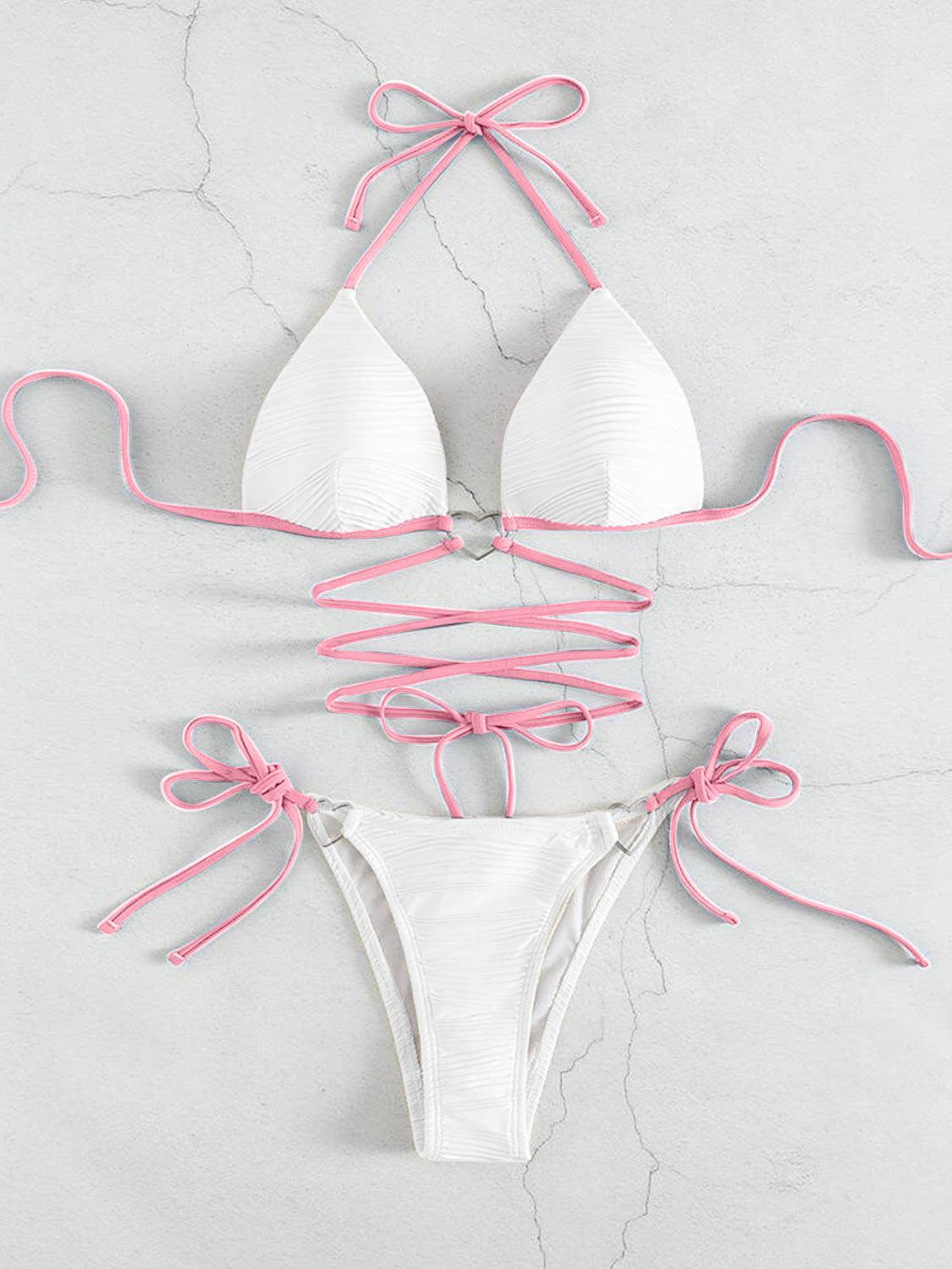 a white bikini with pink ties around it