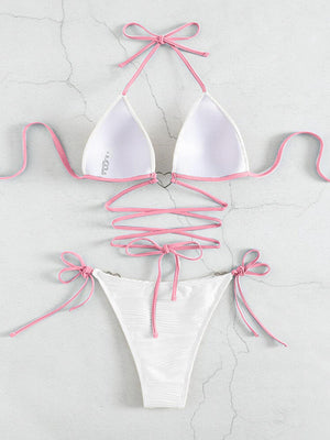 a white bikini with pink ties tied around it