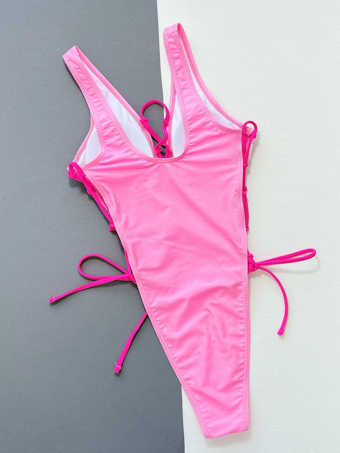 a pink swimsuit laying on top of a white wall