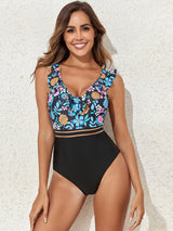 a woman in a black and blue floral print one piece swimsuit