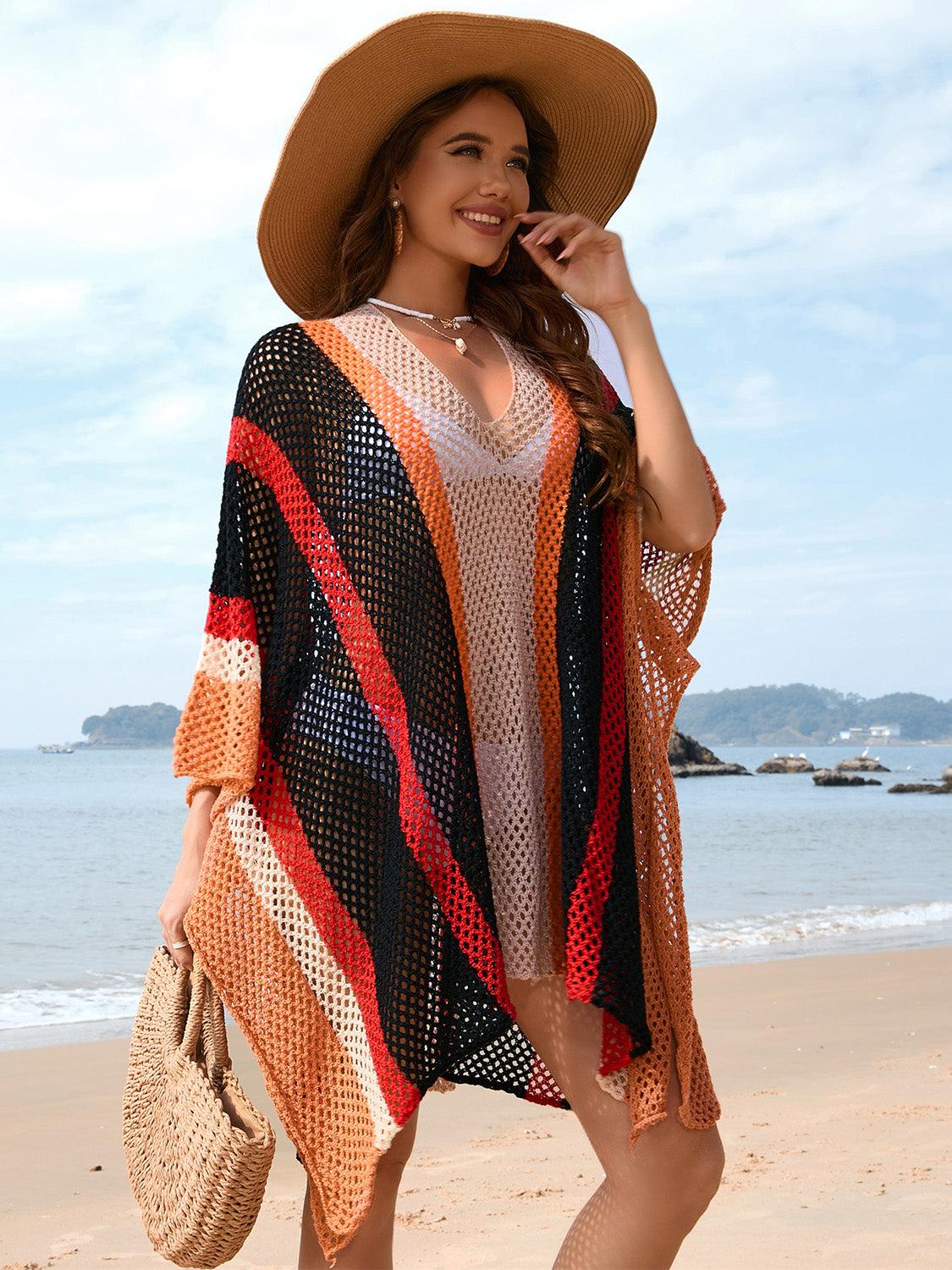 a woman standing on a beach wearing a hat