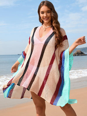 a woman standing on a beach wearing a colorful dress