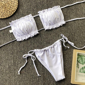 a pair of white bikinis sitting on top of a carpet