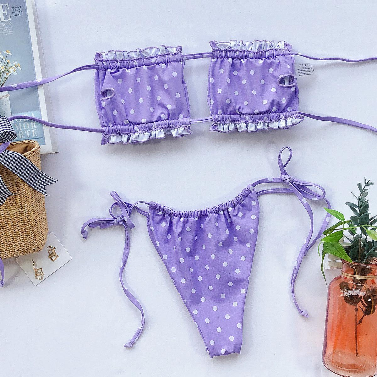 a pair of purple polka dot bikinis next to a potted plant