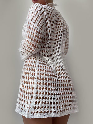 a woman wearing a white crochet dress