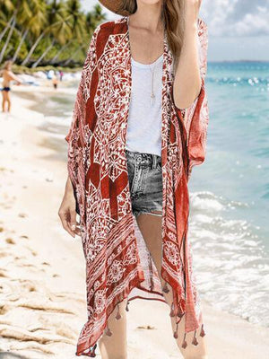 a woman standing on a beach wearing a hat