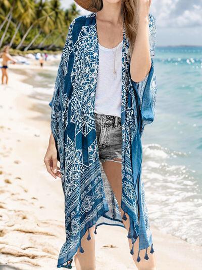 a woman standing on a beach wearing a hat