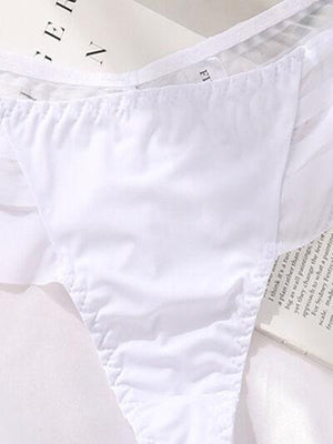 a pair of white underwear sitting on top of a bed