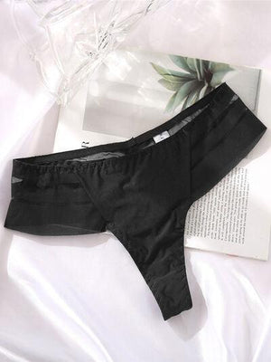 a pair of black underwear sitting on top of a white sheet