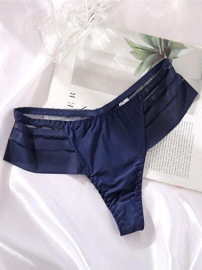 a pair of blue underwear laying on top of a white sheet