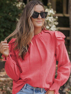 a woman wearing a red blouse and jeans