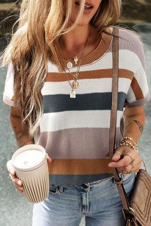 a woman holding a cup of coffee and a cell phone