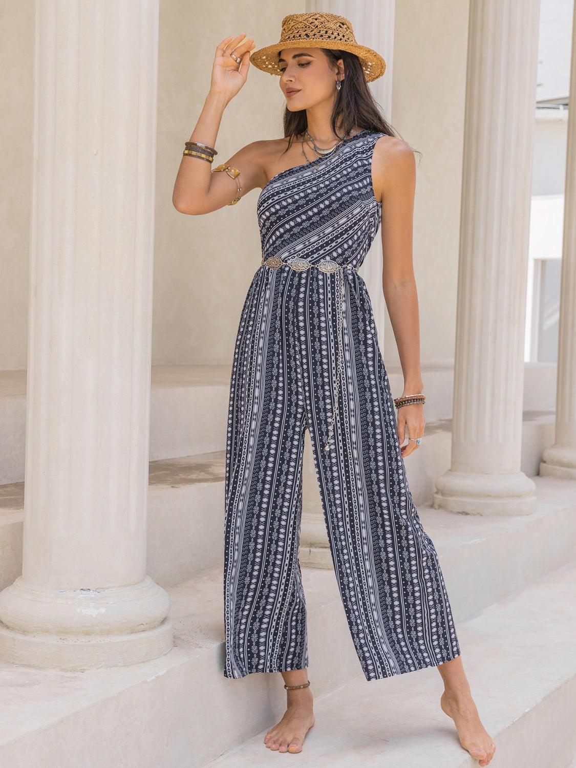 a woman in a one shoulder jumpsuit and straw hat