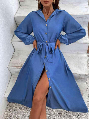 a woman wearing a blue shirt dress with a thigh high slit
