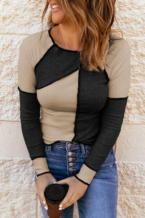 a woman standing against a wall holding a cup of coffee