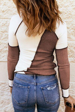 a woman wearing a brown and white shirt and jeans