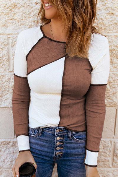 a woman wearing a brown and white shirt and jeans