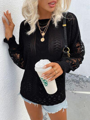 a woman holding a cup of coffee and wearing a black sweater