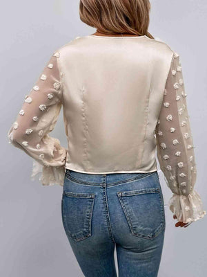 the back of a woman wearing a white blouse and jeans