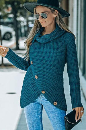 a woman in a blue sweater and hat walking down the street