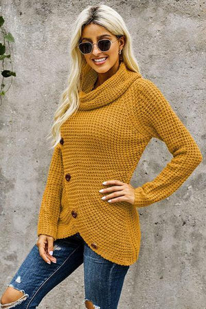 a woman wearing a mustard colored sweater and ripped jeans