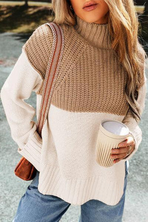 a woman in a sweater and jeans holding a coffee cup