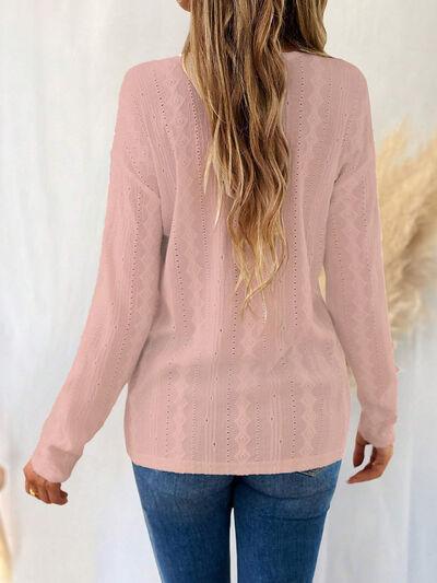 a woman wearing a pink sweater and jeans