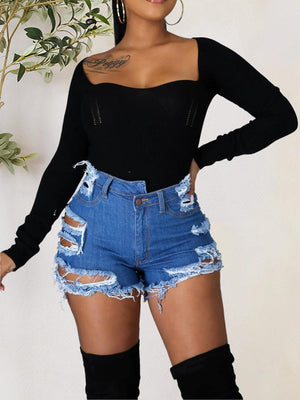 a woman wearing a black top and denim shorts