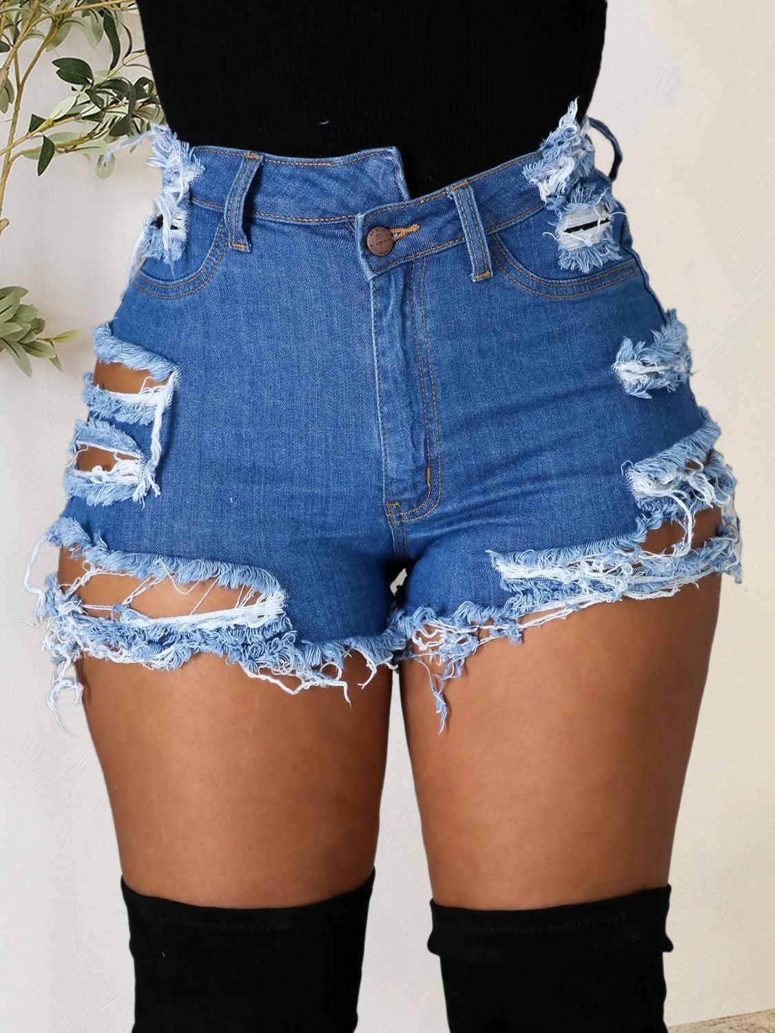 a woman wearing a pair of high waisted denim shorts