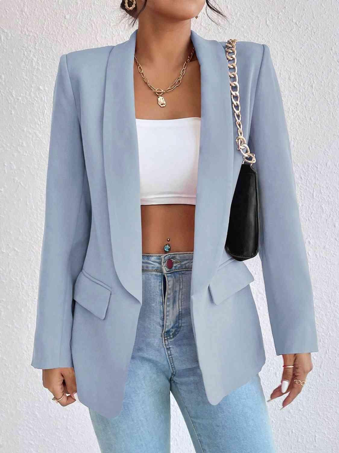 a woman wearing a light blue blazer and jeans