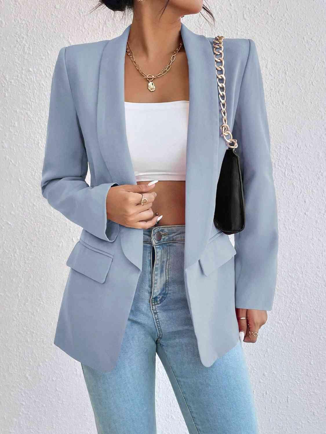 a woman wearing a light blue blazer and jeans