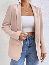 a woman wearing a pink blazer and jeans