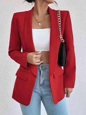 a woman wearing a red blazer and jeans